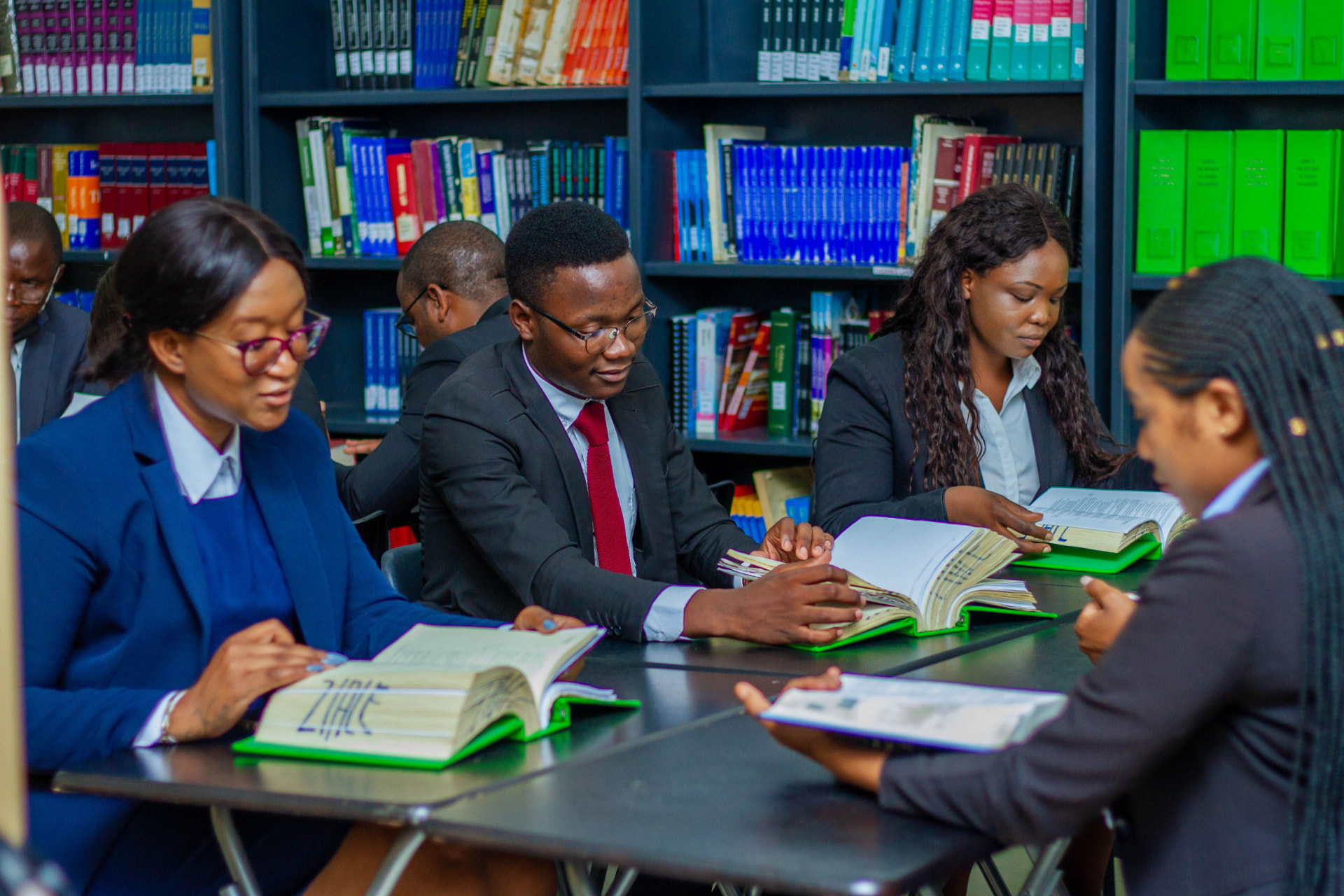 Readers working together with open books at a shared library table