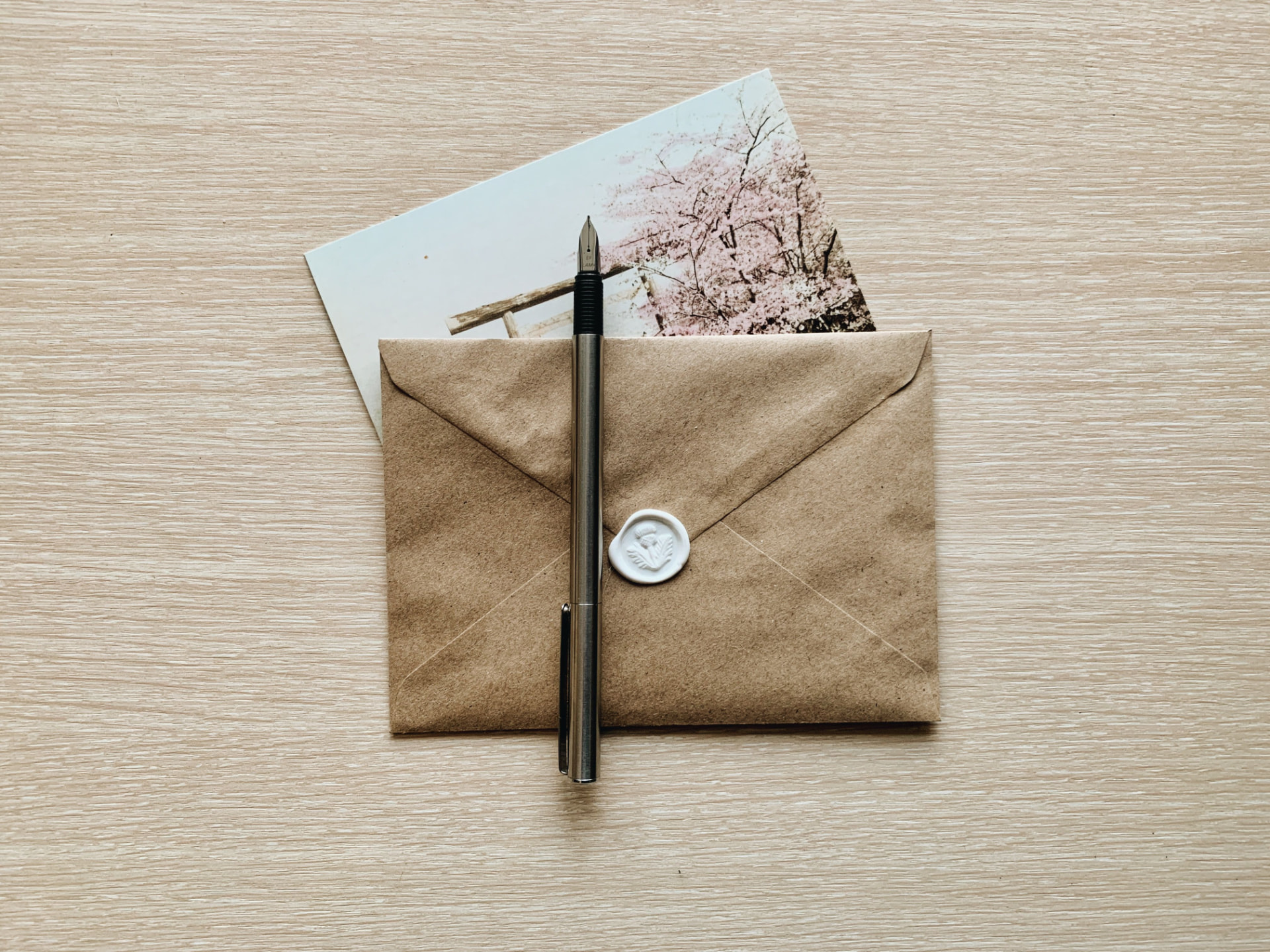 A sealed paper envelope and pen resting on a plain desk